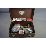 A vintage suitcase containing plastic toy soldiers, horses some by britains and a Dinky Vega Major