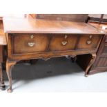 A Georgian style walnut dresser base with three deep drawers, shaped apron, carved cabriole legs and
