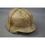 A German SS M40 snow camo helmet - liner present but damaged