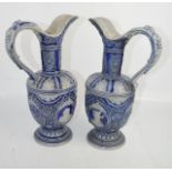A pair of German Simon Peter Gerz salt glazed blue ewers, modelled with portrait roundels and