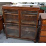 An oak glazed bookcase, with short knop feet, 127cm high, 112 wide, by 31cm deep.