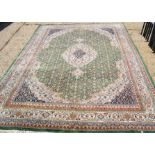 A large wool rug with cream and green ground and borders, 350cm by 245cm.