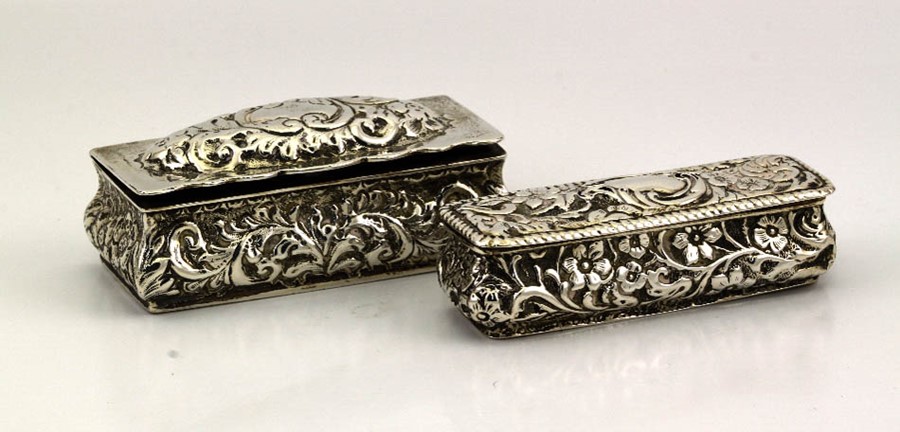 Two silver snuff boxes, 2.58toz, both embossed with floral and scroll decoration.
