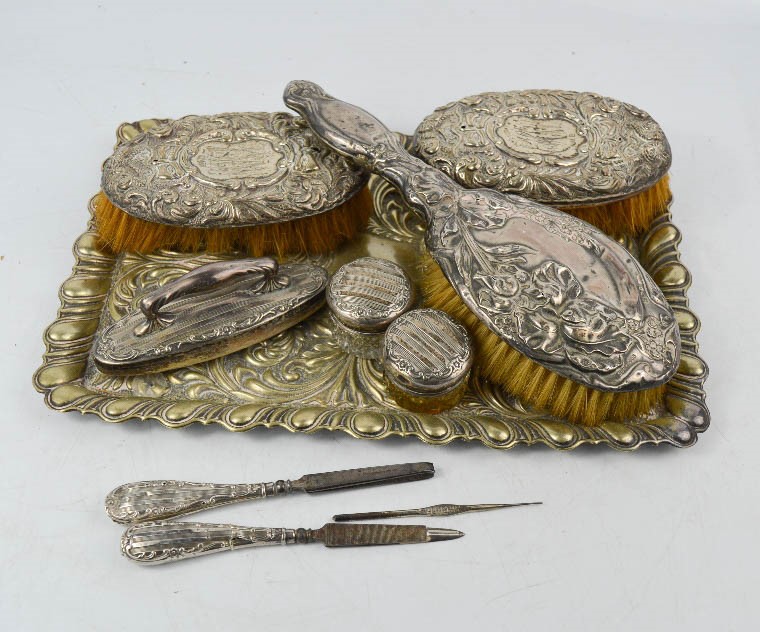 A silver plated tray, together with three silver dressing table brushes, a part silver dressing