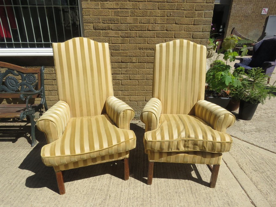 A pair of high back armchairs in a yellow stripe pattern