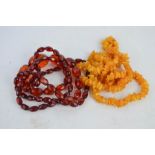 A cloudy amber necklace composed of rough cut graduated beads, together with a red glass necklace