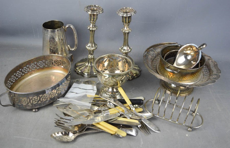 A group of silver plate ware to include pair of candlesticks, fruit basket. toast rack, flatware,