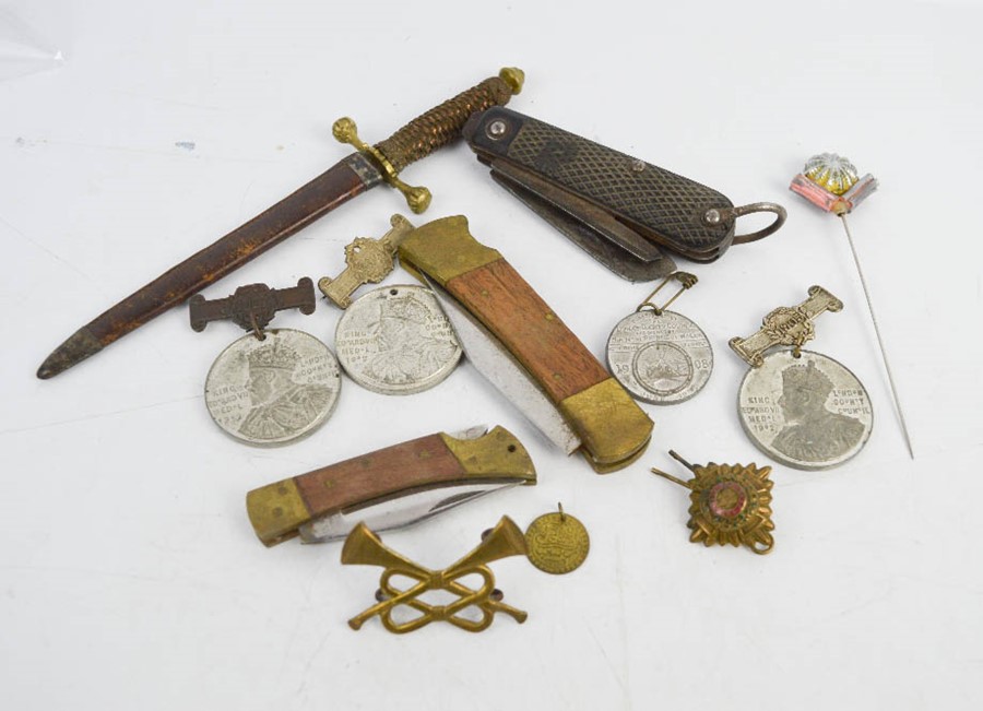 A wartime penknife, a group of medals, band badge and antique letter opener in the form of a sword.