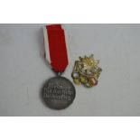 A 1936 German Garmisch Partenkirchen Olympic badge together with a social welfare medal