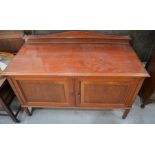 An Edwardian mahogany side board, with shaped back, and two fielded panel doors enclosing shelves,