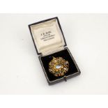 A gilt metal (unmarked) filigree pendant / brooch inset with moonstone, in box labelled JE Bick,