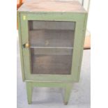A vintage green painted cabinet, with gauze panels to the front door and sides.