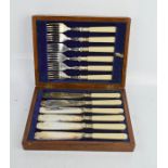 A boxed set of fish knives and forks, with bone handles, and blue leather interior.