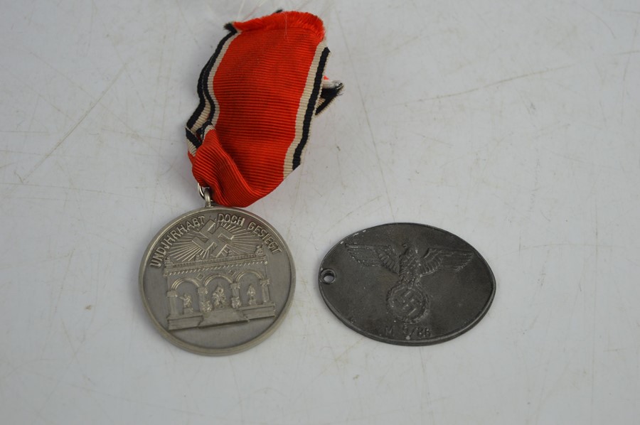 A Munchen 1923-1933 medal together with a Gestapo badge marked M9/86