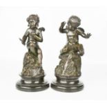 A pair of bronze cherubs,one signed Mayer both raised on marble socle bases.