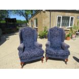 A pair of wing back chairs in blue velvet pattern