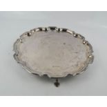 A silver salver, with shaped edge and raised on three feet, Sheffield 1976, Francis Howard Ltd,