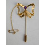 A 9ct gold, diamond and amethyst bow pin, with safety chain, 3.2g.