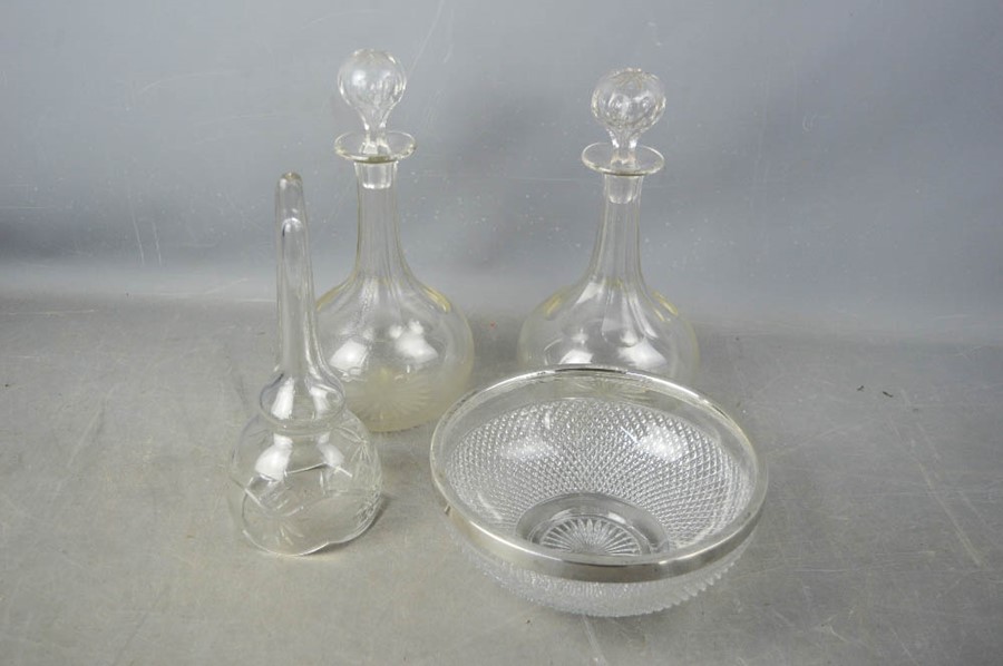 A pair of cut glass decanters, and a siver rimmed cut glass bowl.