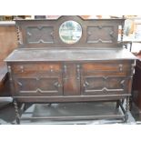 An oak 1940s sideboard with mirrored back, two drawers above two moulded cupboard doors, barley