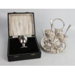 A silver plated egg cup stand with spoons, together with a silver egg cup in presentation case.