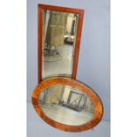 A mahogany wall mirror with bevelled glass, and an oval burr walnut veneered wall mirror.
