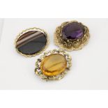 A Pinchbeck brooch set with large amethyst to the centre, an agate example A/F. and a brooch set