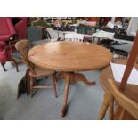 A pine circular top kitchen table, tripod base