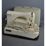 A Nechi sewing machine and case.