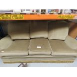 A green velvet three seater sofa and two armchairs