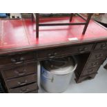 A vintage pedestal desk with red leather top