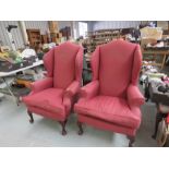 A pair of pink upholstered wingback armchairs.