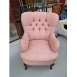 A pink upholstered armchair.
