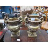 Two resin urns / planters, modelled with cherubs, and gilded.