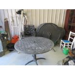 A set of black painted cast iron garden chairs and tables.