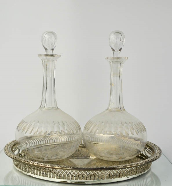 A pair of Edwardian glass decanters, 28cm high, together with a silver plated wine tray.