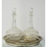 A pair of Edwardian glass decanters, 28cm high, together with a silver plated wine tray.