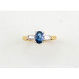 An 18ct gold, sapphire and diamond set ring, the sapphire approx 0.90ct, with baguette cut