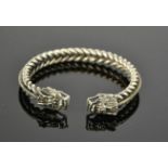 A Tibetan Miao silver dragon bangle, coiled spine 44g. 7.5cm wide