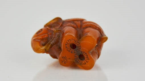 An amber netsuke bead in the form of an elephant, carved with detail, 3cm high. - Image 2 of 2