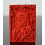 A Chinese finely carved organic cinnebar pendant of 'Guanyin'