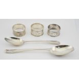 A silver early Georgian serving spoon, a silver dessert spoon and a silver napkin ring with a pair