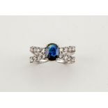 An 18ct white gold, diamond and sapphire ring, the sapphire approx 1ct, centring a bow of diamonds