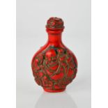 A Chinese handcarved coral colour snuff bottle, having Buddha design