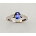 An 18ct white gold, tanzanite and diamond ring, the oval cut tanzanite 0.80ct, and the flanking