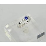 An 18ct white gold three stone diamond and sapphire trilogy ring, size M, 4.4g.