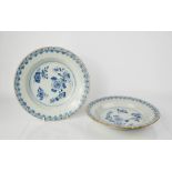 A pair of 19th century blue and white dishes, depicting flowers to the centre, 22cm diameter.