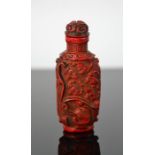 A Chinese hand carved coral coloured snuff bottle, of bees design