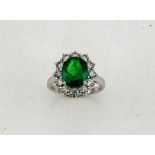 An 18ct white gold, emerald and diamond ring, the central oval cut emerald approximately 2.56ct, and