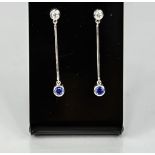 A pair of 9ct white gold, diamond and sapphire drop earrings.